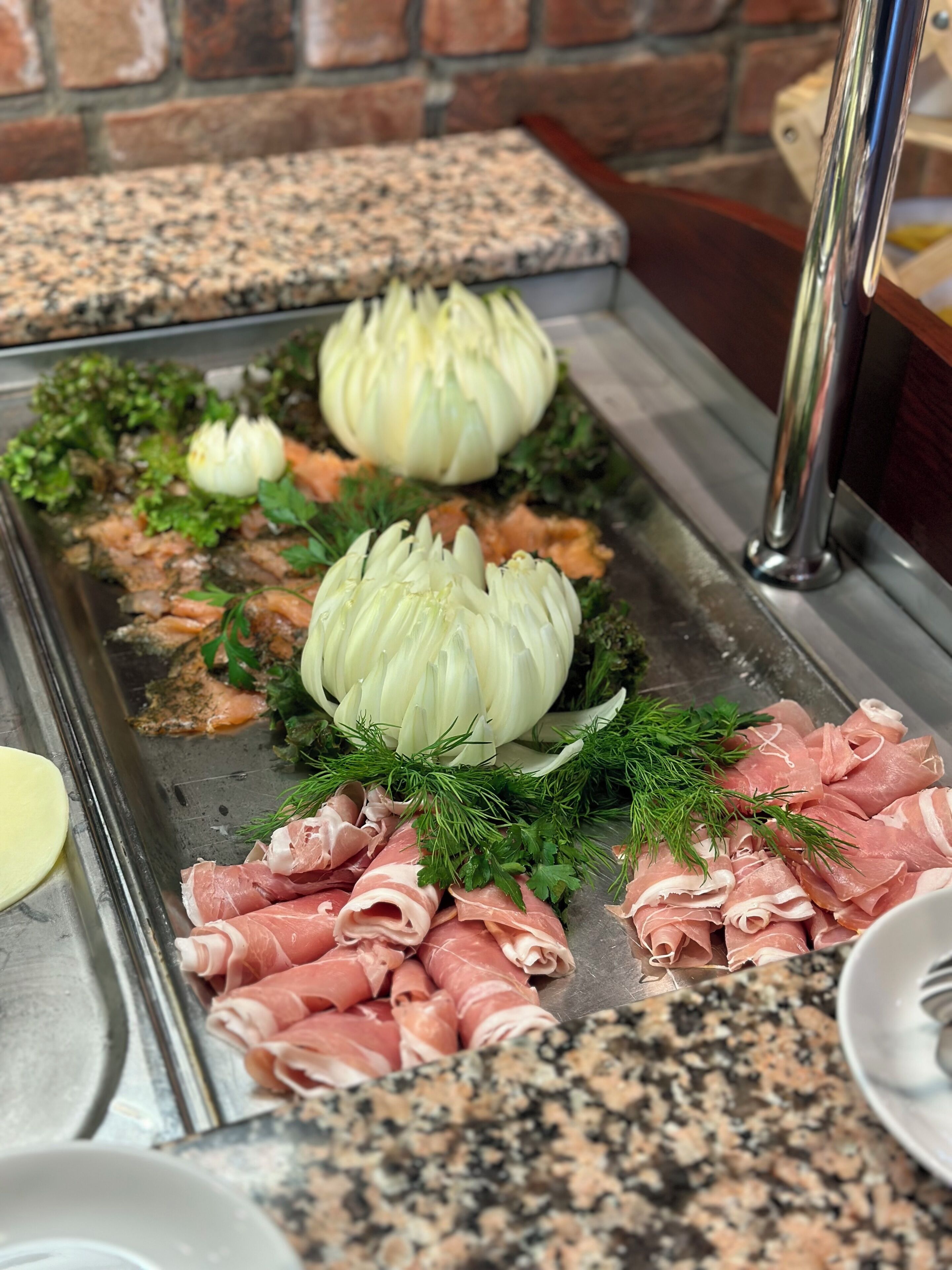 Buffet com diversos tipos de carne, alcachofras e acompanhamentos.