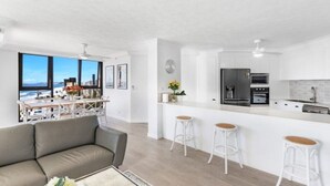 Um apartamento moderno com cozinha, área de refeições e vista para a cidade.