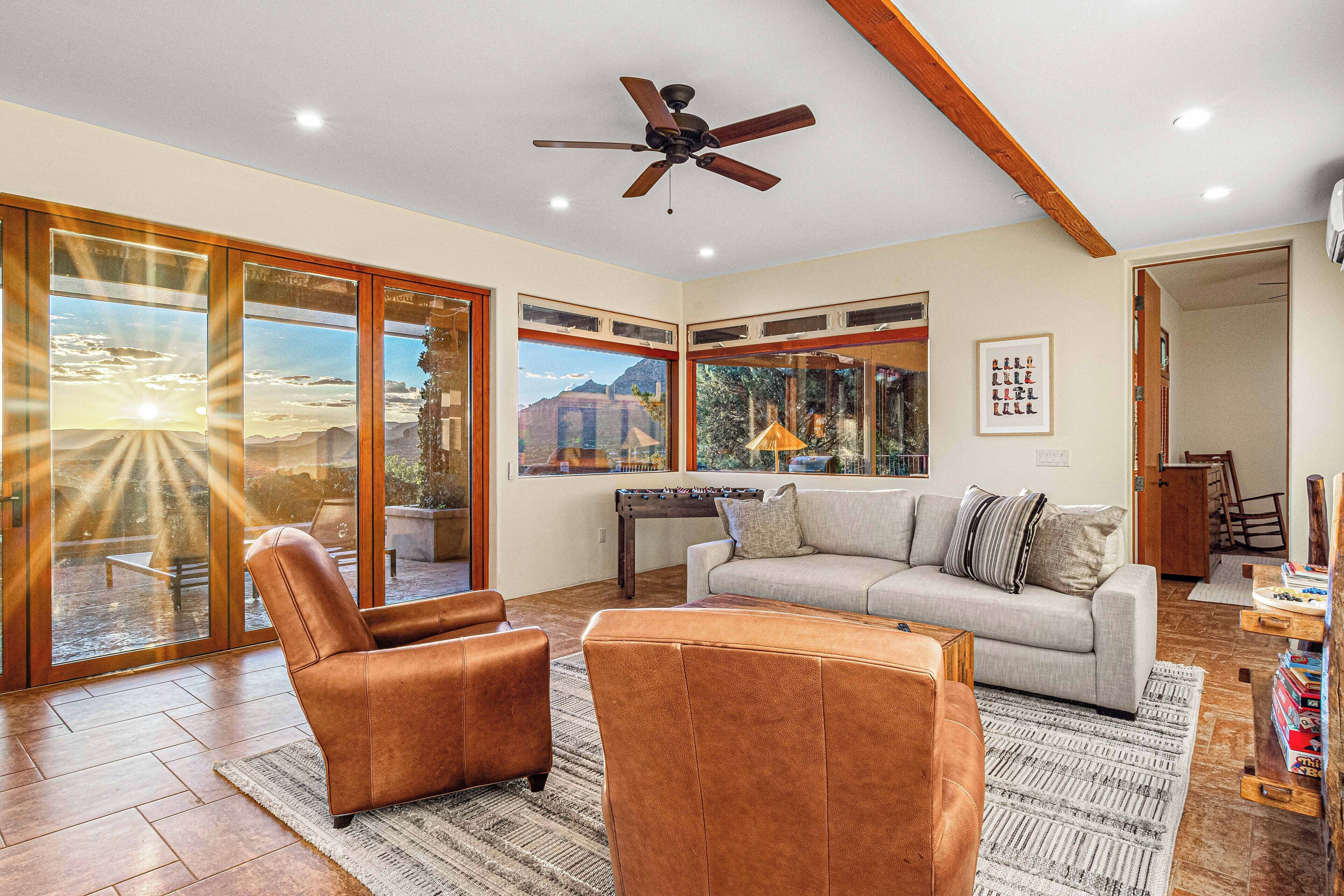 A spacious living room with a large window, a ceiling fan, and a sofa.