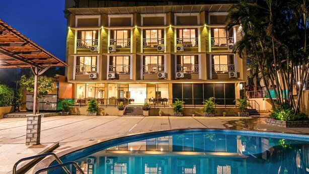 A hotel with a swimming pool, multiple balconies, and outdoor seating areas. - Hotel Sapphire  (Mawal)