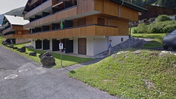 A modern multi-story building with wooden paneling and balconies, set in a mountainous area with a clear sky. - Cozy studio near ski area with parking (Châtel)