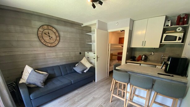 A compact living space with a sofa, a small kitchen area, and a dining table. - Cozy studio near ski area with parking (Châtel)