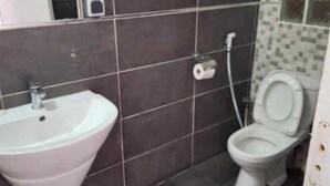 A bathroom with a sink, toilet, and a mirror. - 3 Chambres Salon (Saint Louis)