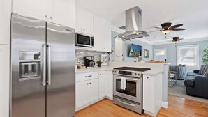 Una cocina moderna con electrodomésticos de acero inoxidable, un microondas y un horno.
