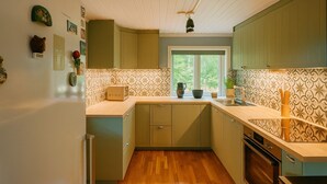 Una cocina con armarios de madera, una ventana y una encimera con un tostador.