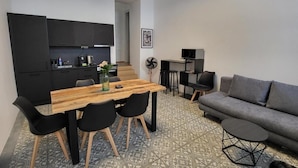 Ein kompakter Wohnraum mit einer Küchenzeile, einem Essbereich und einer Sitzecke.