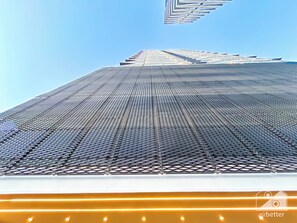 A high-rise building with a grid-like facade and a clear sky. - Chic 1-br Apt & Balcony in Binghatti Heights (Dubai)