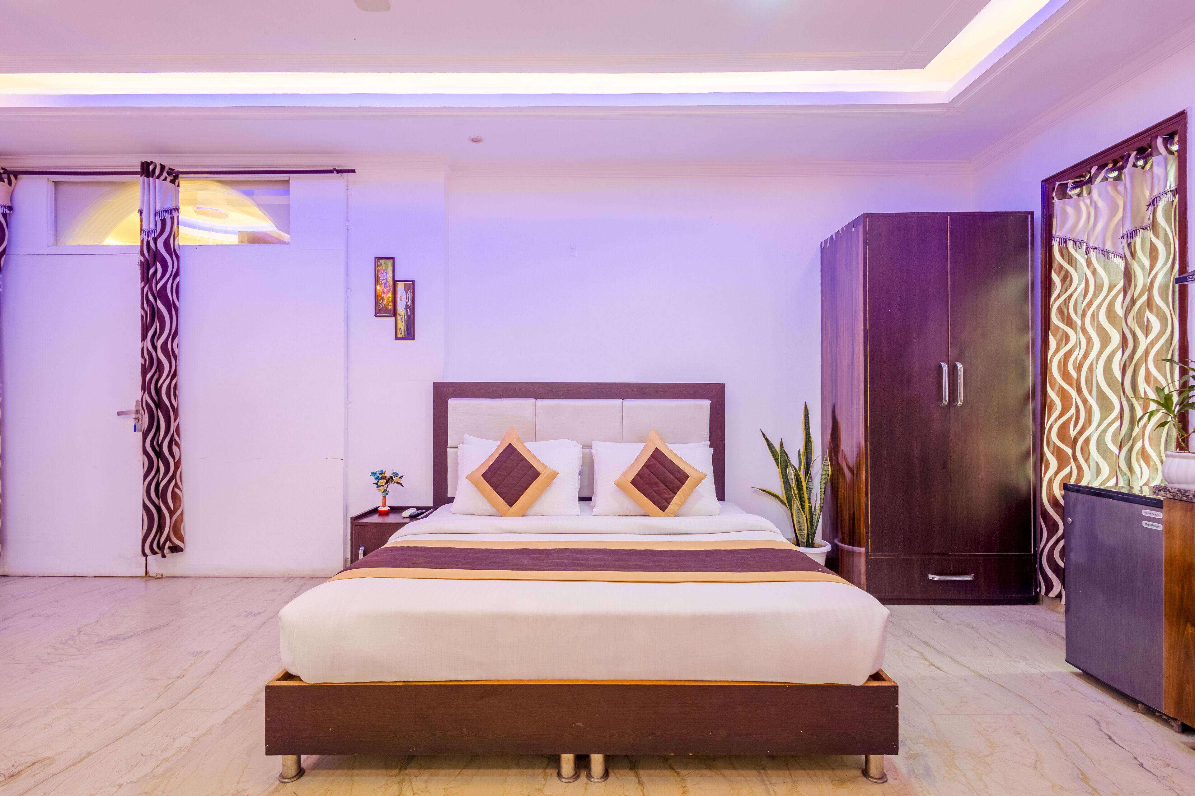 A modern bedroom with a large bed, a wardrobe, and a nightstand.