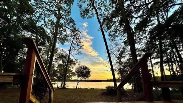 A wooden deck with a view of a lake and trees. - Lakefront Bliss | Kayaks • Paddleboards • Fire Pit • Snowbird Specials (Melrose)