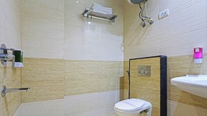 A modern bathroom with a toilet, sink, and shower. - Hotel Smart Lax (New Delhi)