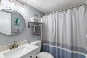 Secador de cabelo, toalhas de banho, papel higiênico