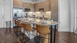 A modern kitchen with a central island, stainless steel appliances, and pendant lighting. - Luxurious New Unit|2Bd2Ba|Pool, Golf Sim (Austin)