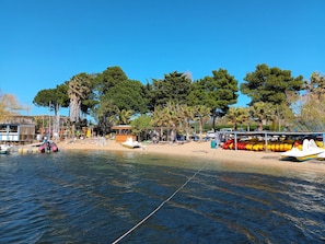 A beachside area with boats, a wooden structure, and trees. - Location au Pied du lac Marin T2 Port Leucate (Leucate)