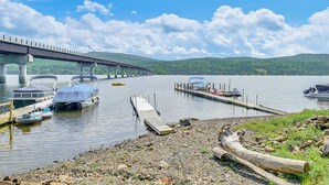 A lakeside dock with boats, a bridge, and a dock extending into the water.
