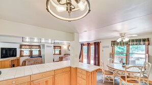 A spacious kitchen with wooden cabinets, a large island, and a dining area with a table and chairs.