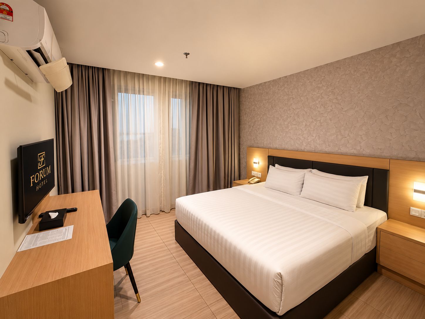 A hotel room with a bed, bedside table, nightstand, desk, chair, and a wall-mounted air conditioning unit.