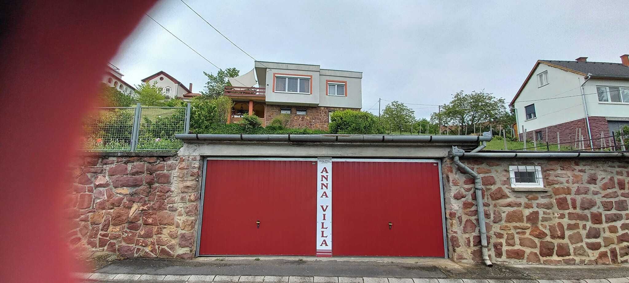 Une porte de garage rouge avec une enseigne indiquant « ANAVILLA ».