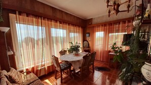 A cozy dining area with a round table, chairs, and a chandelier. - Anna Villa Apartment Badacsony (Badacsonytomaj)