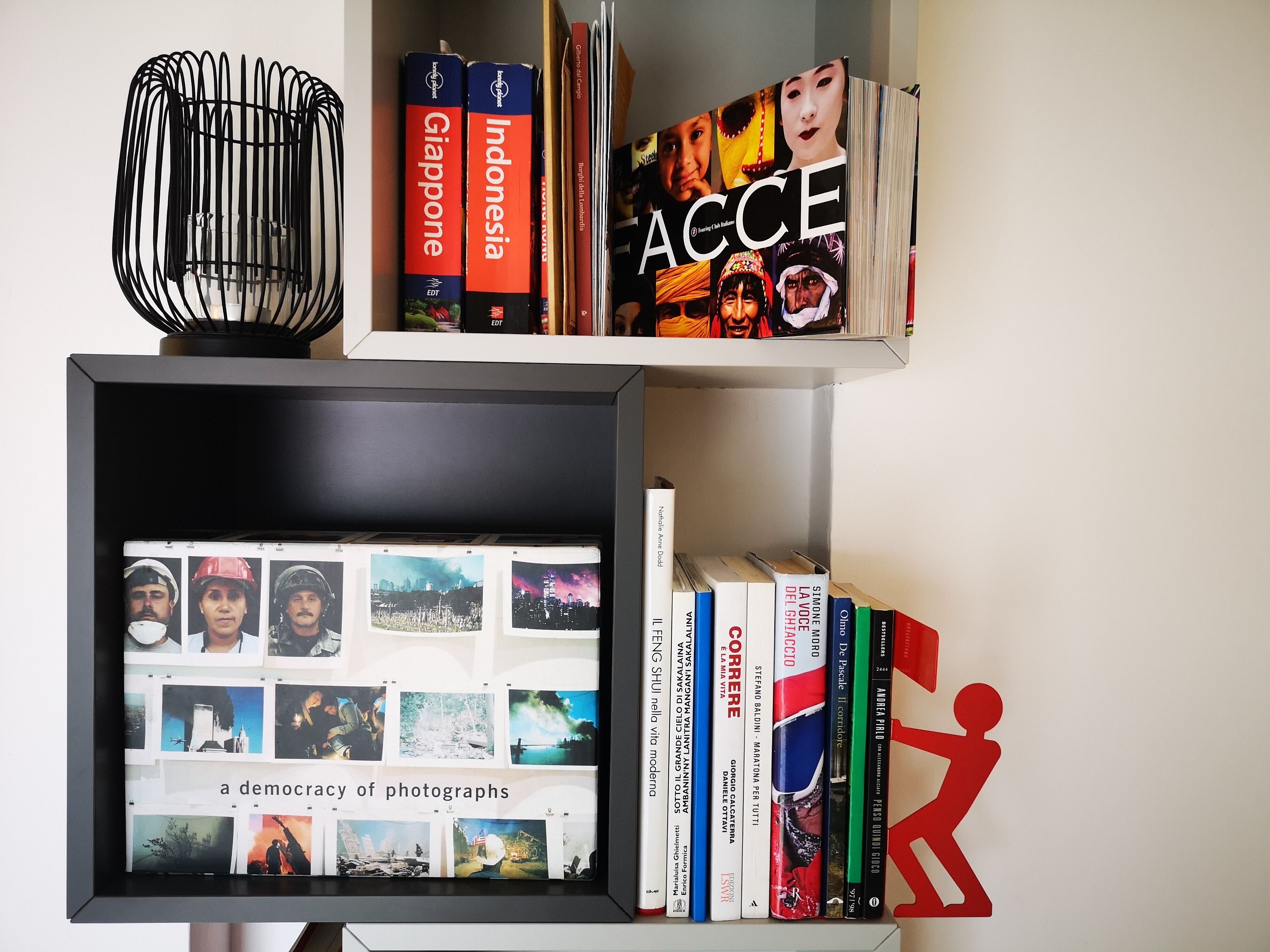 Una estantería con libros y un collage enmarcado de fotografías.