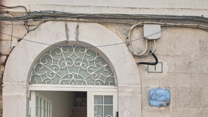 A staircase leading to a door with decorative metalwork and a sign above it. - Magic and Enchantment, comfortable apartment in the heart of Trani's historic center (Trani)