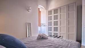 A bedroom with a bed, a wardrobe, and a mirror. - Magic and Enchantment, comfortable apartment in the heart of Trani's historic center (Trani)