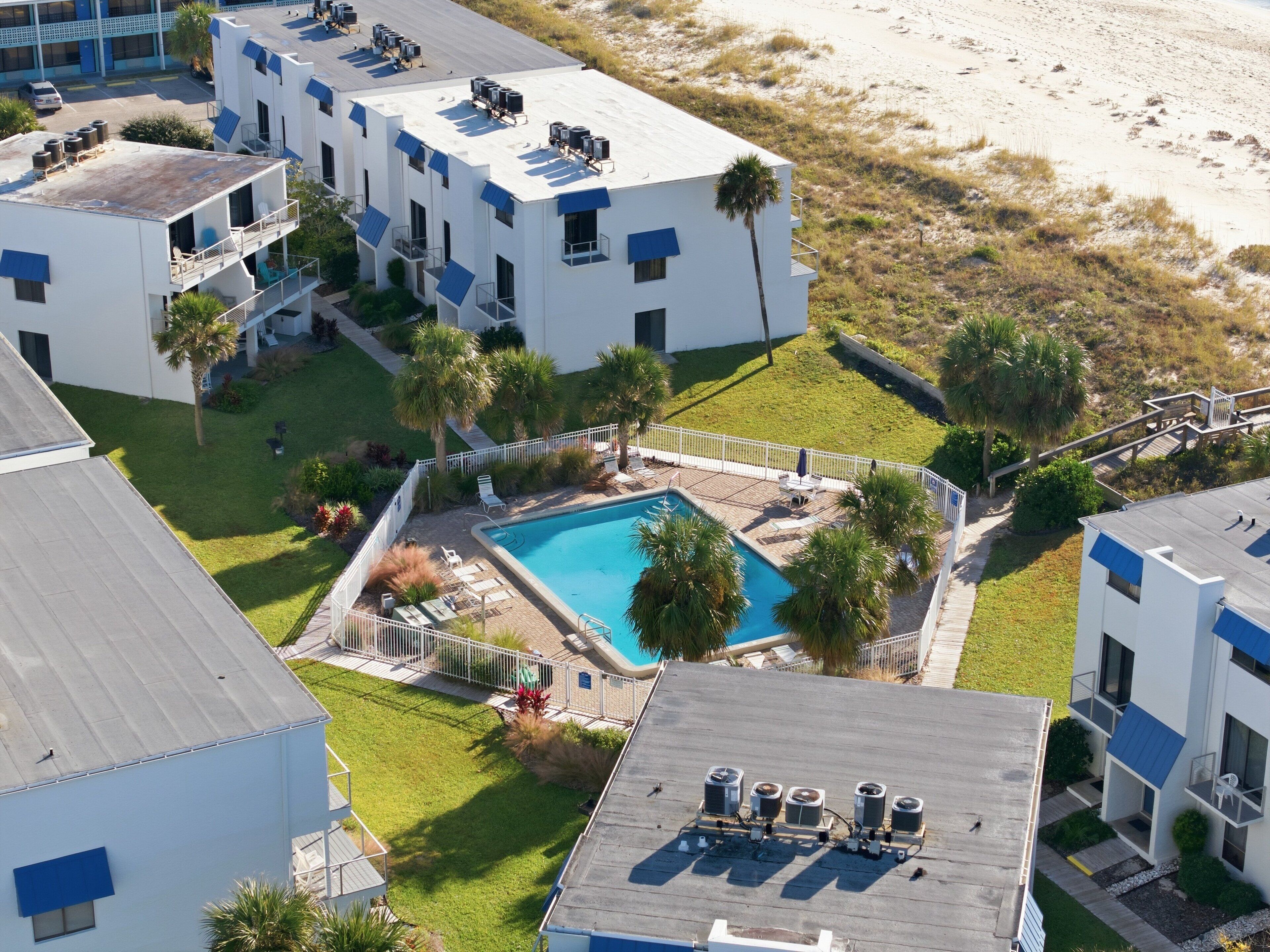 Ein modernes Hotel mit Dachpool, mehreren Klimaanlagen und Blick auf den Strand.