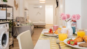 A breakfast table with croissants, strawberries, and orange juice.