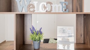 A reception area with a 'Welcome' sign, a potted plant, and a framed informational poster.