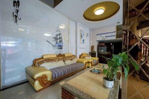 Ein modernes Wohnzimmer mit einer Couch, einem Couchtisch und einer Topfpflanze.