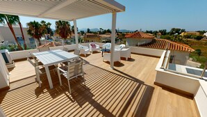 A rooftop terrace with a table and chairs, a pergola, and a view of the surrounding landscape. - Sunset by ON Travel (Oliva)