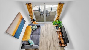 A modern living room with a gray sofa, a painting, a TV, and a wooden floor. - On the Water 5 A One-of-a-Kind Stay | Free Parking | By My Getaways (Brighton)