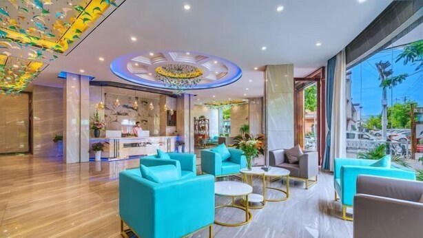 A modern hotel lobby with teal sofas, gold-framed coffee tables, and a central chandelier. - Ningyu Lianchuang Business Hotel (Ning'er)
