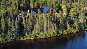 A cabin surrounded by dense forest and a lake. - Auberge Boréale de Charlevoix (Petit-Saguenay)