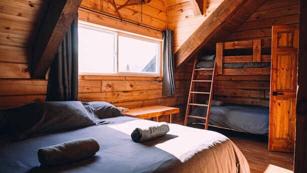 Een knus kamer met een slaapzolder, een ladder en een stapelbed.