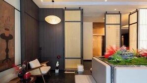 A modern interior with a sofa, chairs, a hanging light, and a decorative plant. - Floral Hotel·Yangshuo Shiyin Yue Hotel (Yangshuo Xijie Shili Hualang Branch) (Yangshuo)
