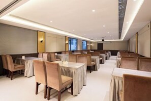 A hotel dining area with multiple tables and chairs, recessed ceiling lighting, and large windows. - Floral Hotel·Yangshuo Shiyin Yue Hotel (Yangshuo Xijie Shili Hualang Branch) (Yangshuo)