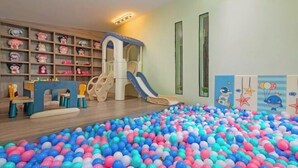 A children's play area with a ball pit, a slide, and shelves with toys. - Floral Hotel·Yangshuo Shiyin Yue Hotel (Yangshuo Xijie Shili Hualang Branch) (Yangshuo)