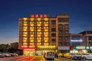 Un hôtel à plusieurs étages, doté d’une entrée imposante, de plusieurs places de stationnement et d’une devanture bien visible avec une enseigne.