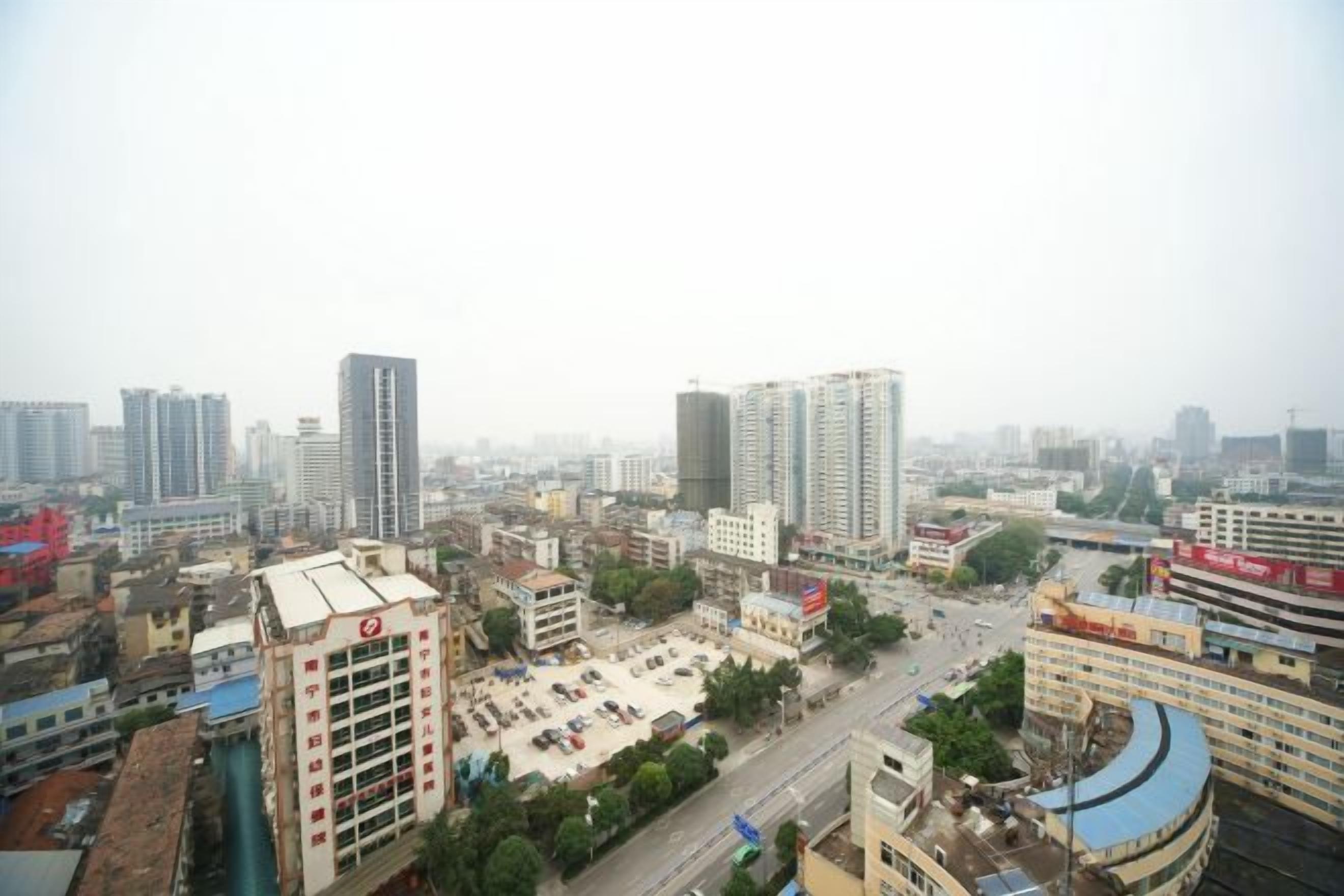 Un paysage urbain avec de hauts immeubles, un parking et une route.