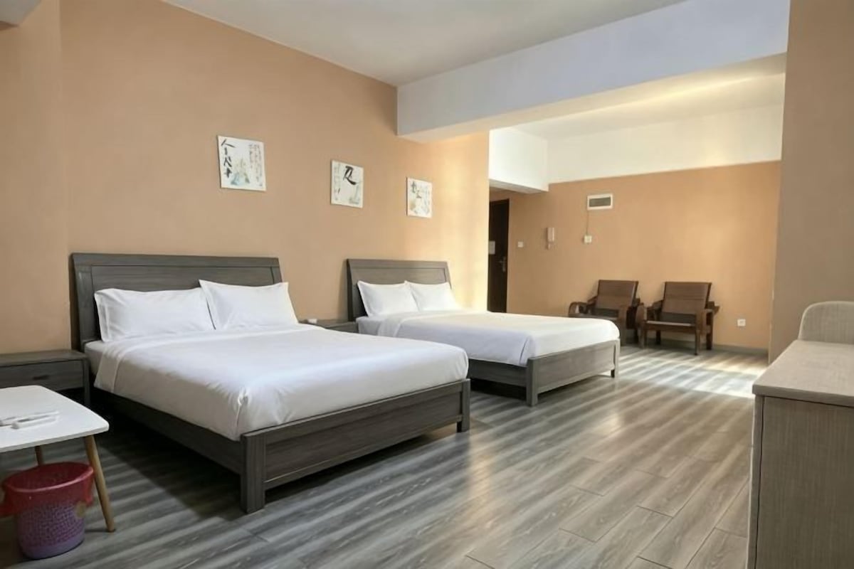 Une chambre d’hôtel avec deux lits, une petite table et une chaise.