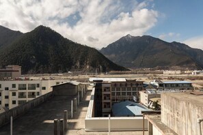 Un edificio con techo plano y vistas a montañas al fondo.