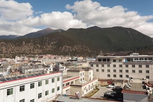 Un pueblo con edificios y una montaña al fondo.