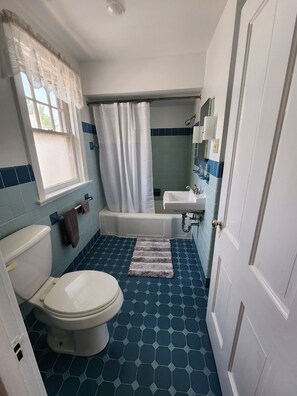 A bathroom with a toilet, bathtub, and sink.