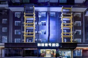 Un hotel con fachada moderna, varios balcones y una entrada destacada.