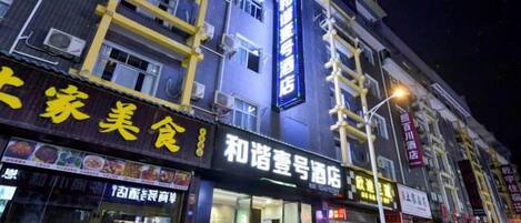 A building with multiple storefronts, including one with a sign that reads '和谐咖啡厅' (Harmony Coffee House).