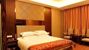 A hotel room with a large bed, a nightstand, a desk, and a chair. - Wangyanlou Hotel (Yueqing)