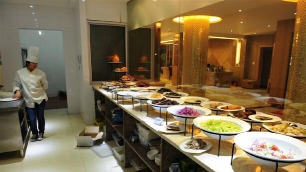 A buffet setup with various dishes and a chef preparing food. - Wangyanlou Hotel (Yueqing)