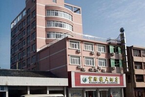 A multi-story building with a commercial ground floor featuring signage for a restaurant. - Wangyanlou Hotel (Yueqing)