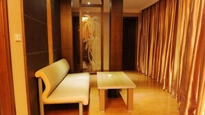 A hallway with a bench and a table, wooden flooring, and curtains on one side. - Wangyanlou Hotel (Yueqing)