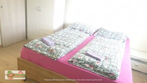 Ein Schlafzimmer mit zwei Betten, einem Kleiderschrank und einem Willkommensschild.